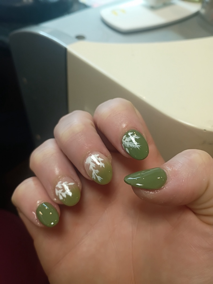 Olive-green almond nails with white hand-painted botanical sprigs.