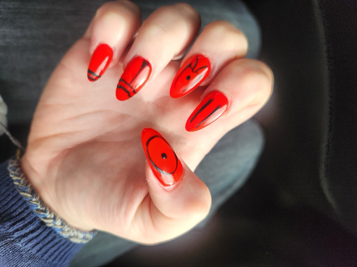 Bright-red nails with fine black abstract line art.